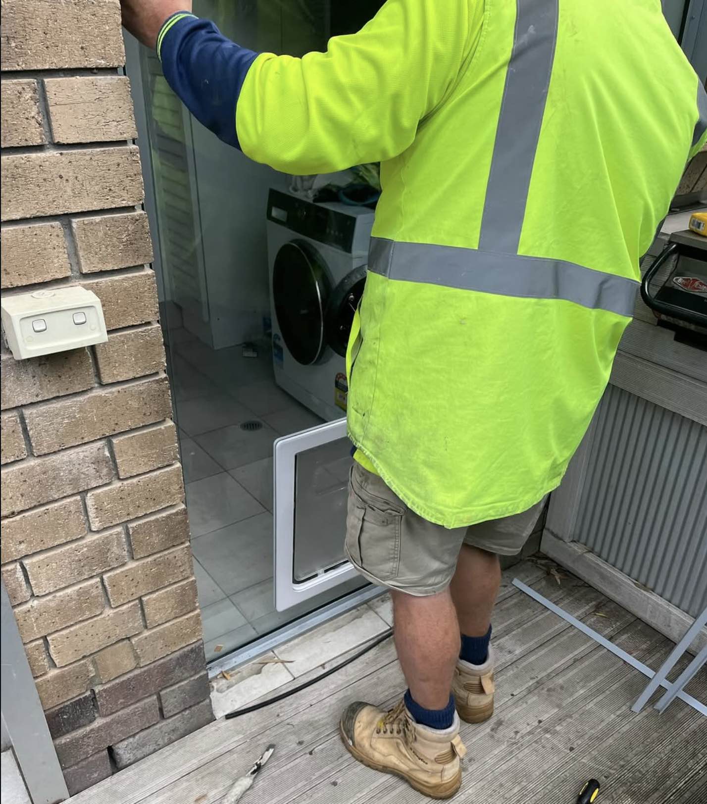 Dog Door Australia installing a Large Dog Door into a fixed glass panel